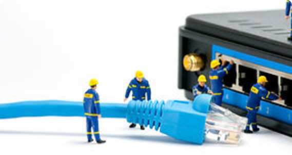 Small working men plugging network cable into giant switch